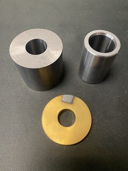 A set of three different types of metal parts in various shapes and sizes.